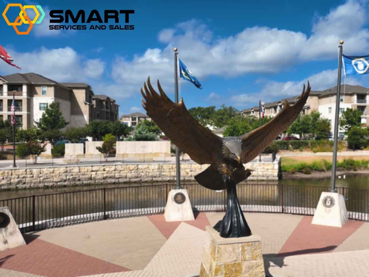 A bronze eagle statue with outstretched wings stands on a pedestal overlooking a river in Leander TX